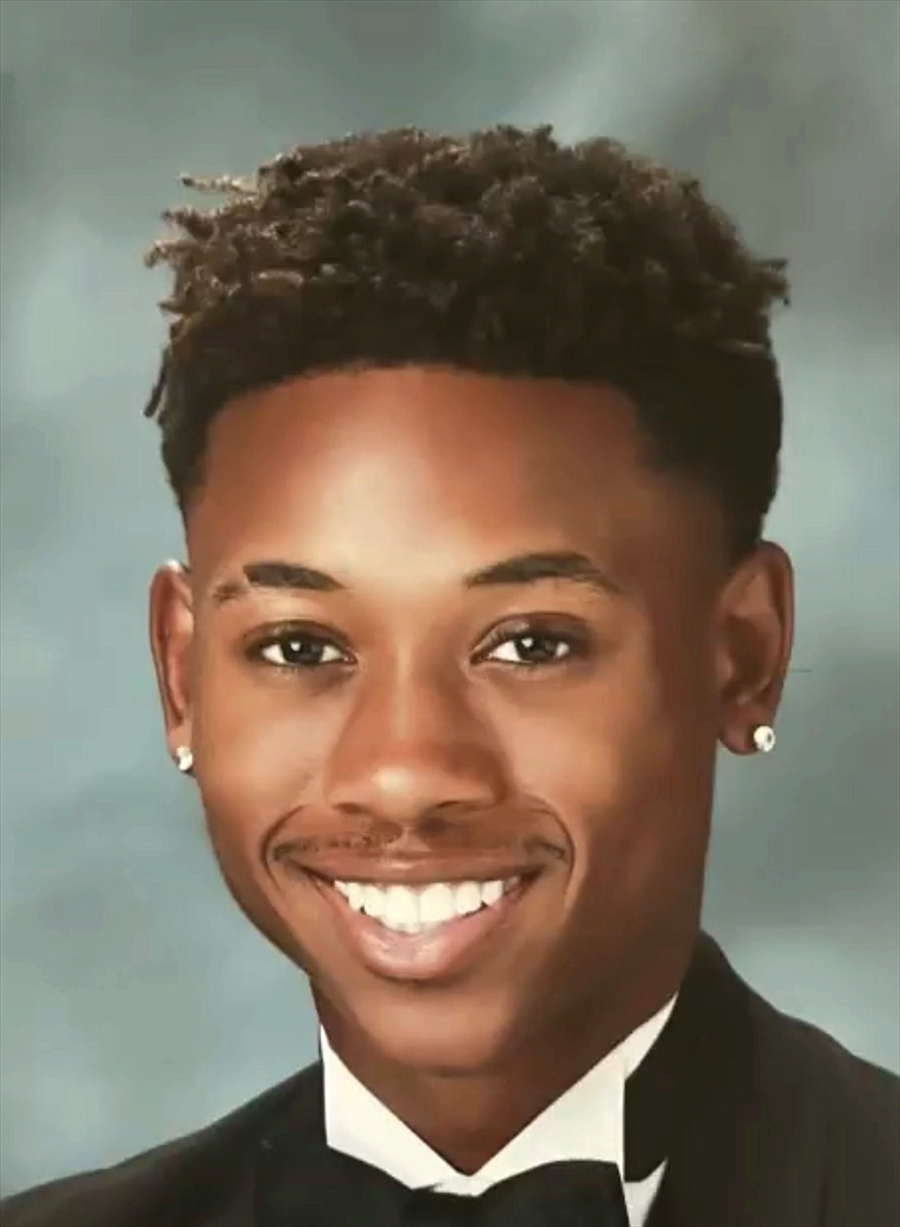 Tyler smiling in a black tuxedo and bow tie for his high school portrait